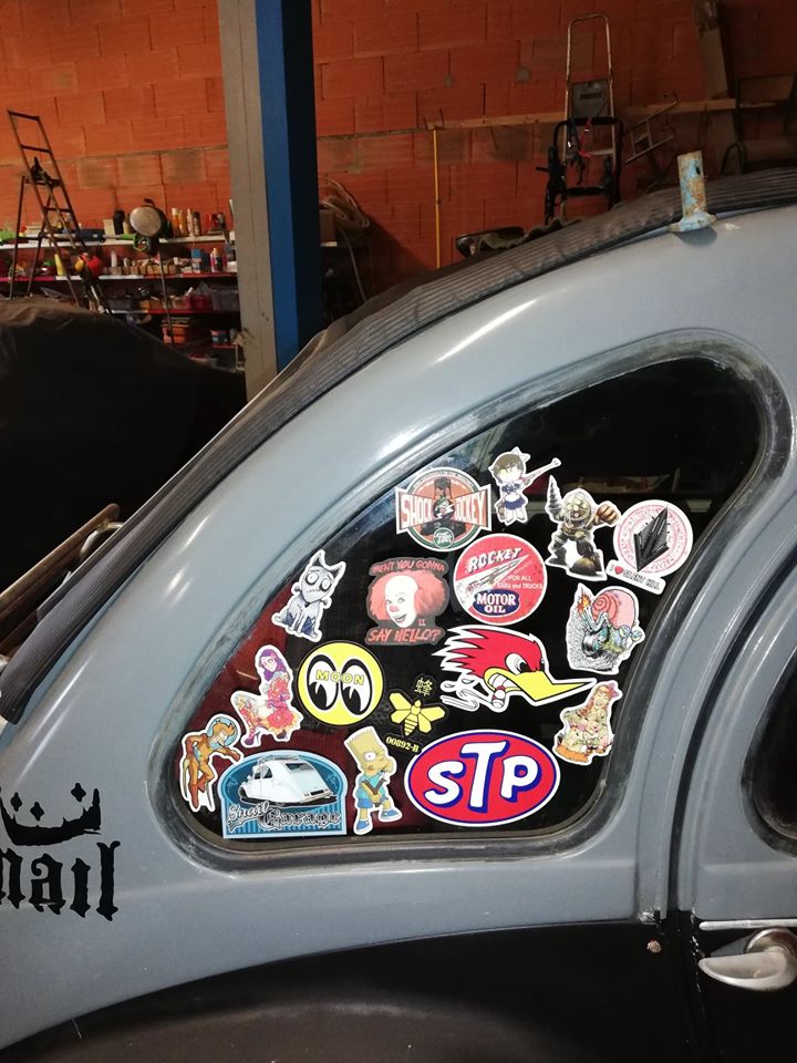 Détail d'une 2CV6 relookée : vitre de custode à stickers et lettrage peint sur la carrosserie grise