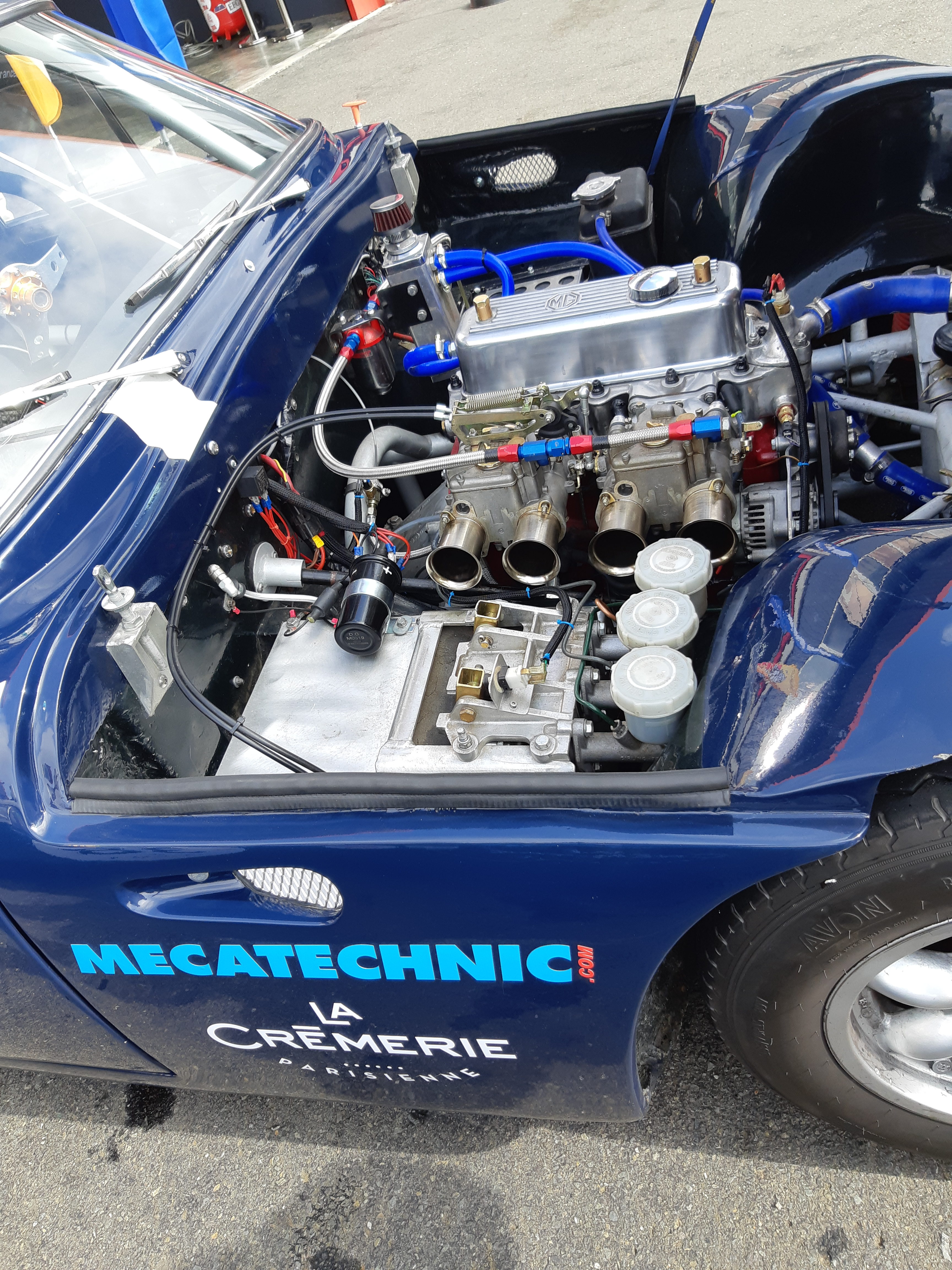 Moteur à carburateurs double corps d'une voiture historique bleue aux couleurs de Mecatechnic, dans la voie des stands du Vigeant