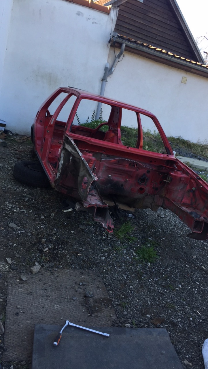 Caisse de Golf 2 GTD rouge entièrement démontée, posée au sol devant un mur avant restauration